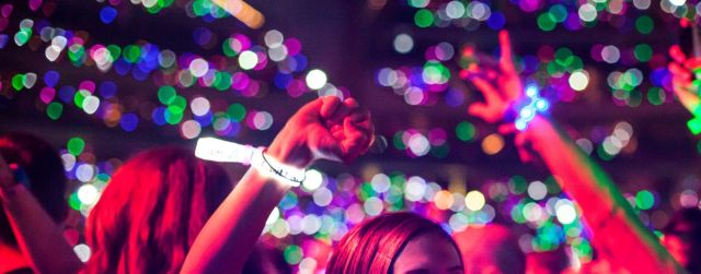 Colourful LED wristbands glowing at a concert event