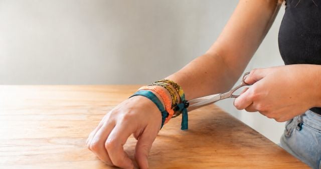 A festival wristband being cut off with scissors after an event