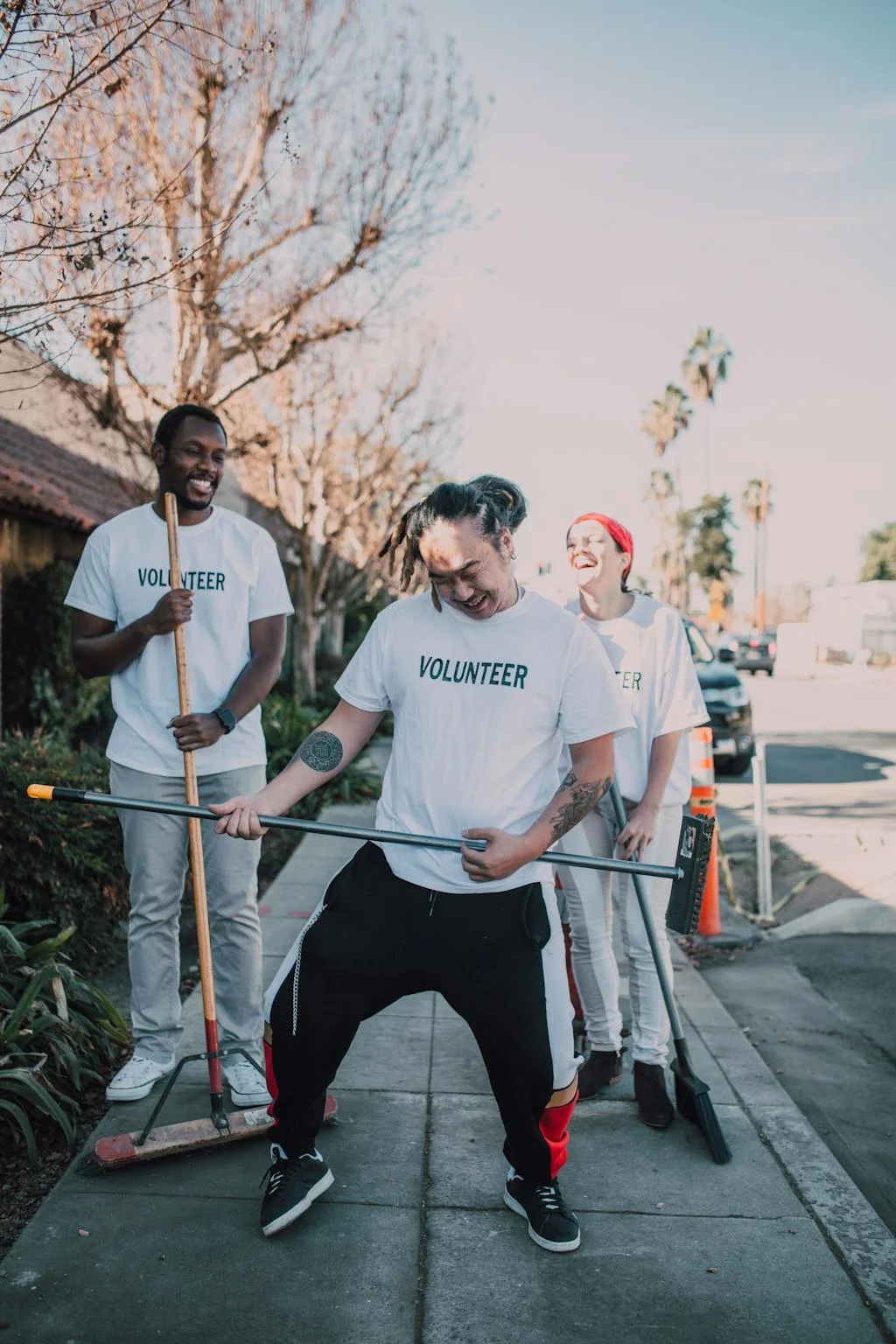 Three volunteers in T-shirts laughing during a community fundraising effort — wristband fundraising ideas