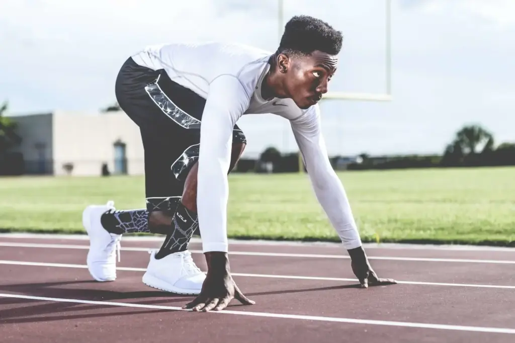 Young male athlete at the starting line on a running track