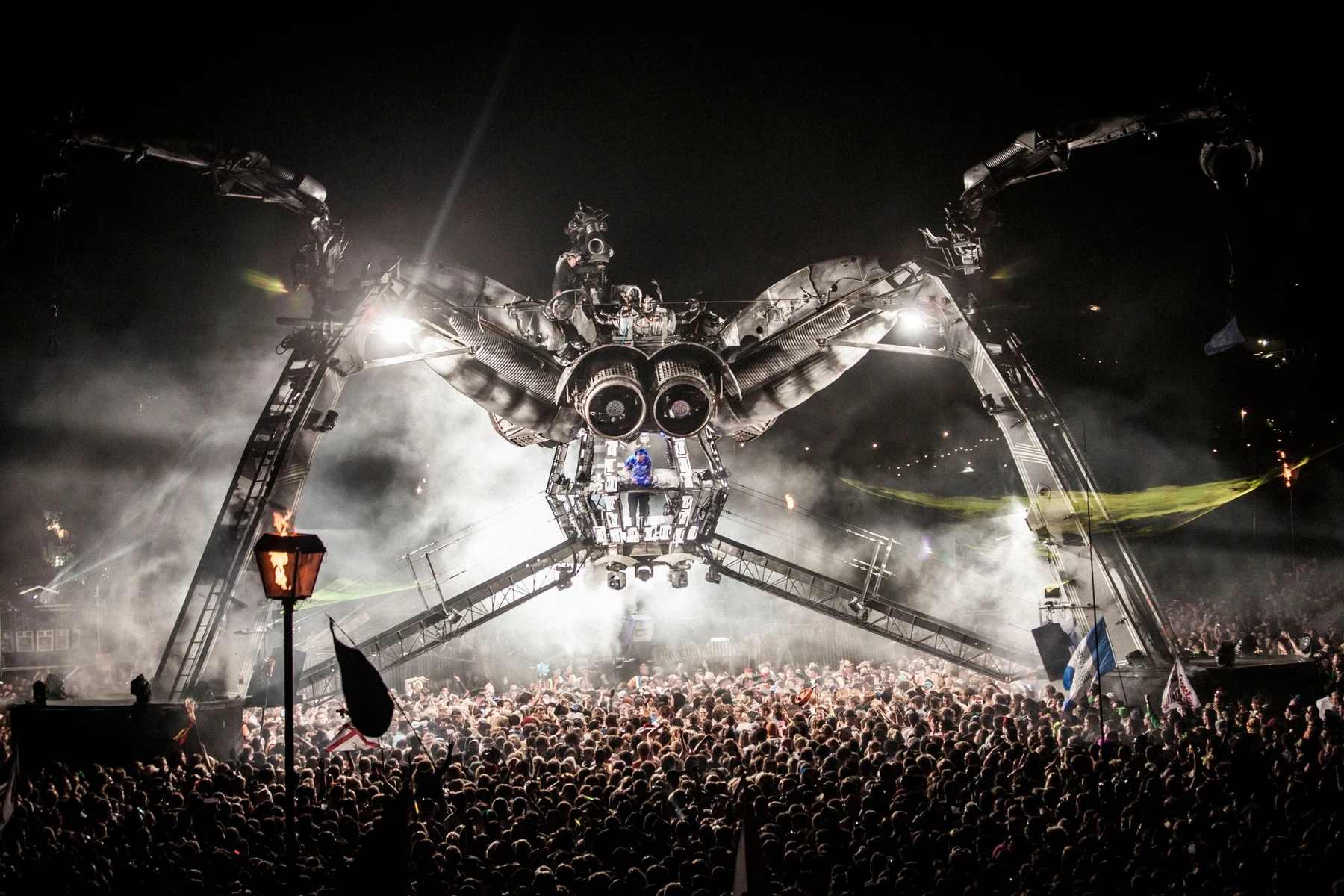 A large festival crowd at night in front of a lit main stage, showing the scale of an event audience