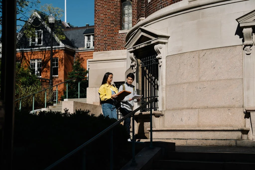 Two students walking down school steps with notes — planning a Walk for Water charity fundraiser
