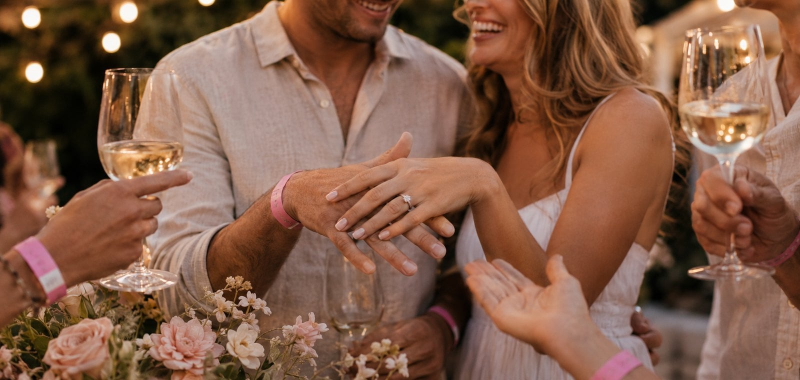 Engagement party guests wearing custom colour-coded event wristbands at the bar