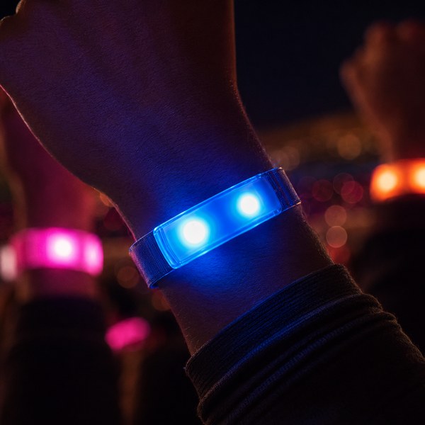 Close-up of a single LumoSynch LED wristband lit on a wrist