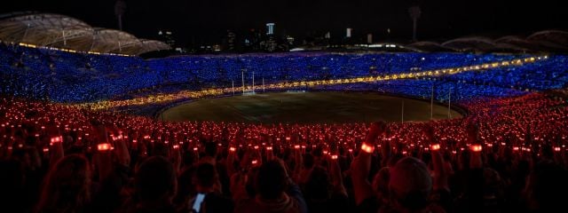 A night event crowd lit up by glowing wristbands