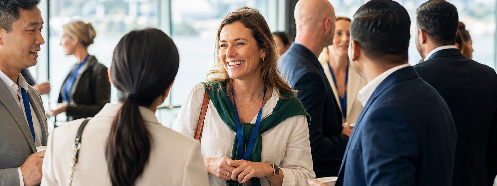 Corporate networking event with business professionals mingling and wearing event lanyards at a launch reception